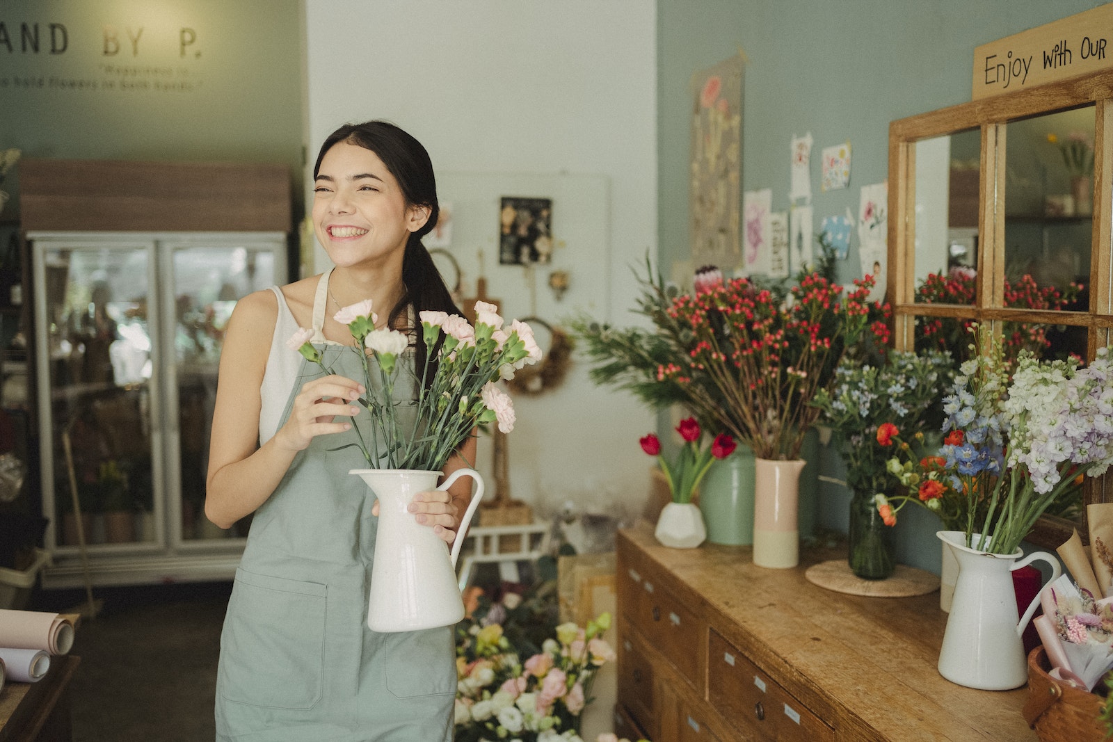 Happy florist standing with vase of flowers