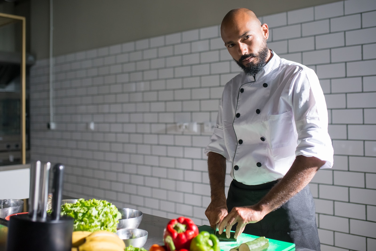 Chef slicing on a Green Chopping Board