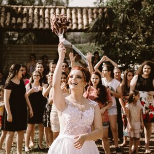 bride throwing flower bouquet on women during daytime